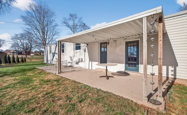 a backyard of a house with table and chairs