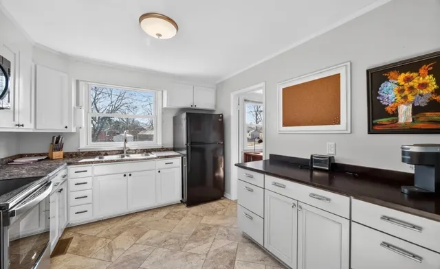 a kitchen with granite countertop a sink stainless steel appliances and cabinets