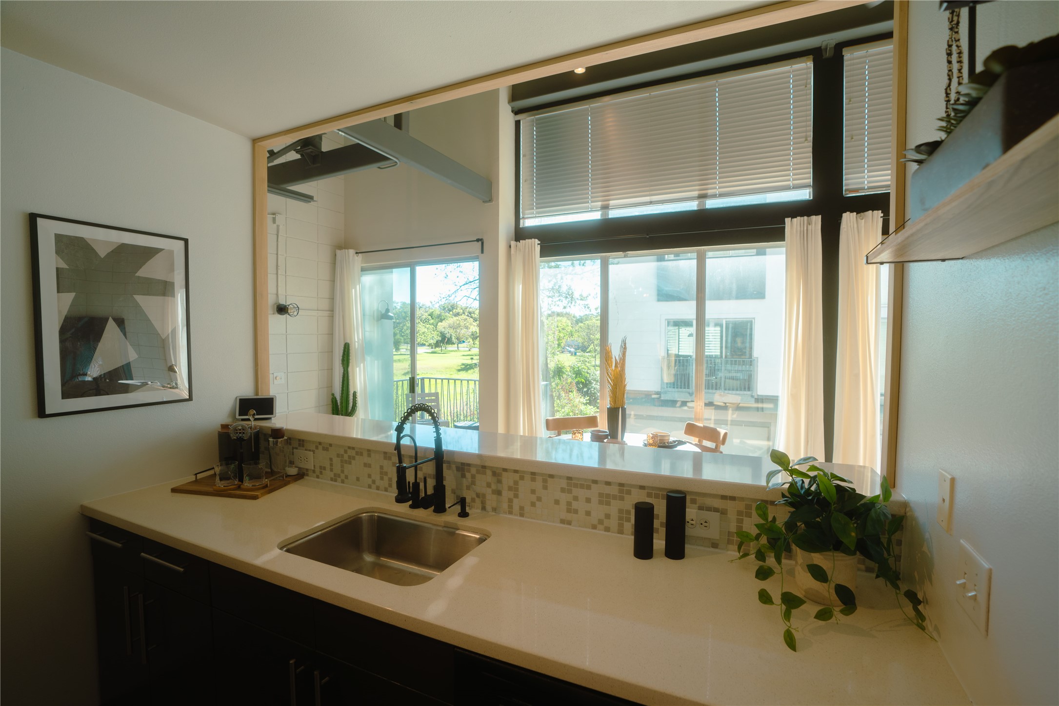4801 South Congress Avenue, Unit H5 Austin, TX 78745 - Photo 16 of 39 Kitchen with dark cabinetry, a peninsula, and light stone countertops