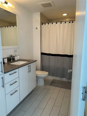 a bathroom with a sink a toilet a mirror and shower