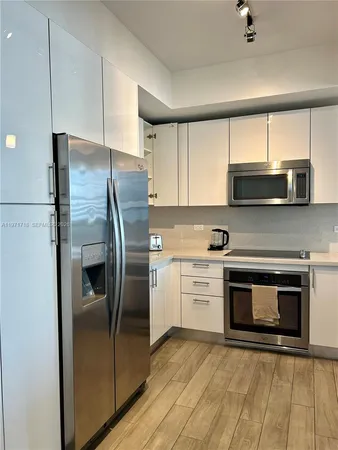 a kitchen with stainless steel appliances a refrigerator sink and microwave