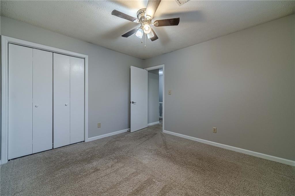1220 Fieldgate Road Lawrenceville, GA 30044 - Photo 25 of 45 an empty room with closet and a chandelier fan