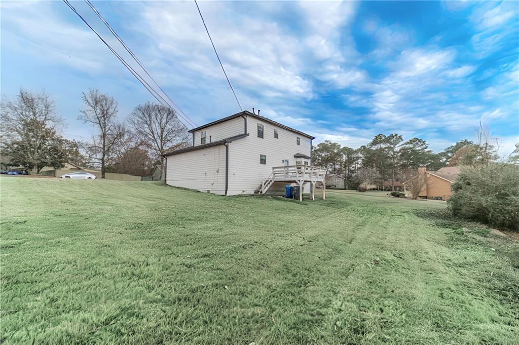 1220 Fieldgate Road Lawrenceville, GA 30044 - Photo 3 of 45 a view of a big house with a big yard and large trees