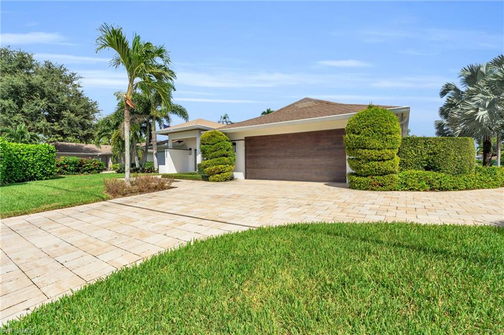 a front view of a house with a yard and potted plants