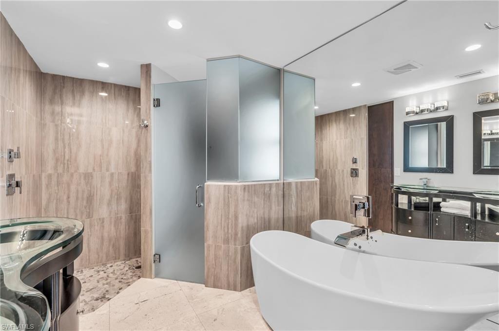 5000 West Boulevard Naples, FL 34103 - Photo 12 of 25 a bathroom with a tub a sink a washer and dryer