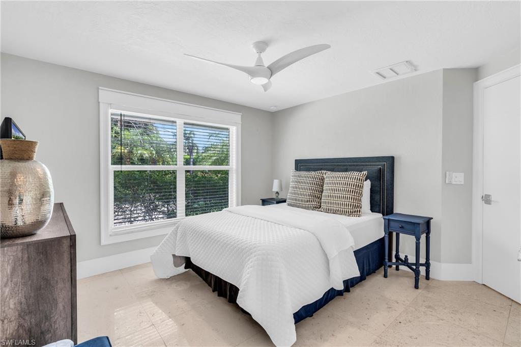 5000 West Boulevard Naples, FL 34103 - Photo 17 of 25 a large bed sitting in a bedroom next to a window