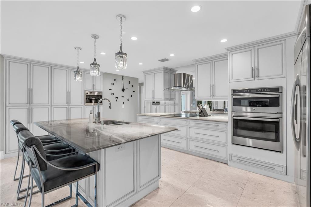 5000 West Boulevard Naples, FL 34103 - Photo 8 of 25 a kitchen with stainless steel appliances kitchen island granite countertop a stove and cabinets