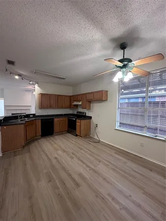 a large kitchen with stainless steel appliances granite countertop a stove and a wooden floors