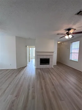 a view of empty room with wooden floor and fireplace