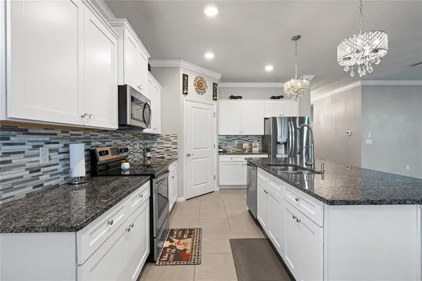 a kitchen with stainless steel appliances granite countertop a sink refrigerator and cabinets