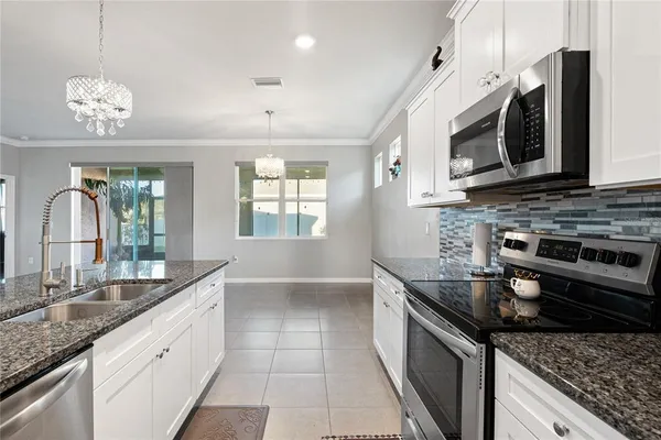 a kitchen with stainless steel appliances granite countertop a sink and a stove
