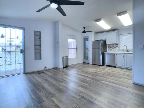 a view of kitchen with refrigerator microwave and wooden floor