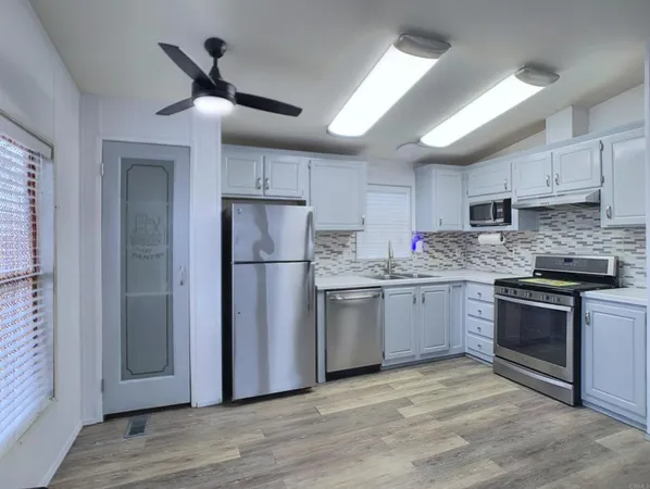 a kitchen with a refrigerator sink and cabinets