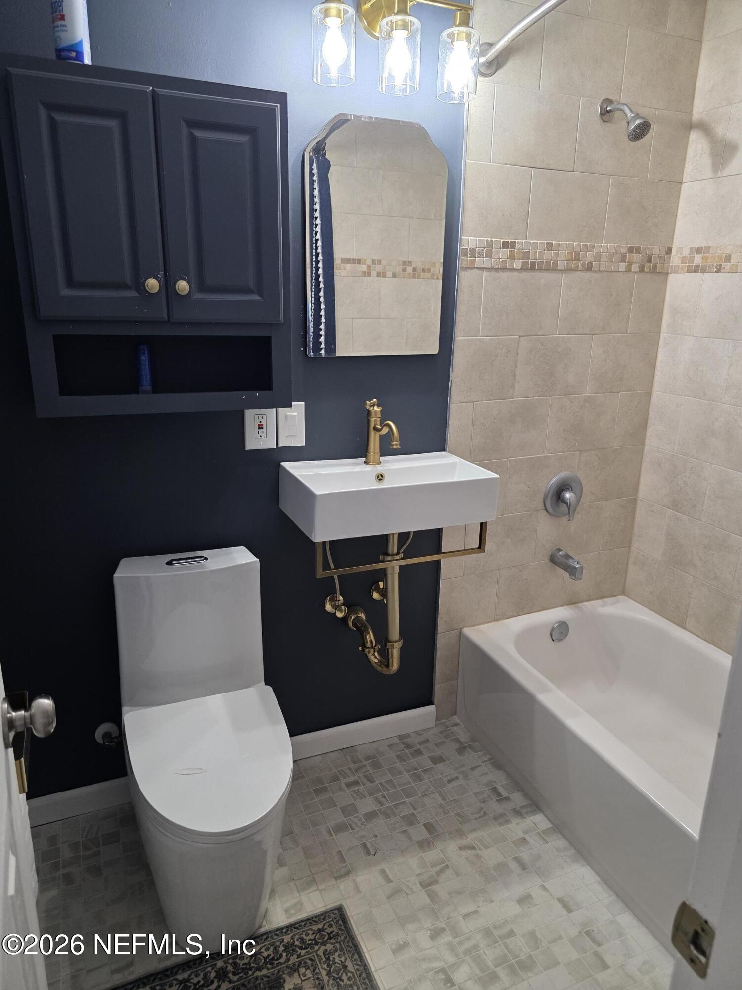 3616 Toledo Road Jacksonville, FL 32217 - Photo 18 of 34 a bathroom with a toilet a sink and bathtub