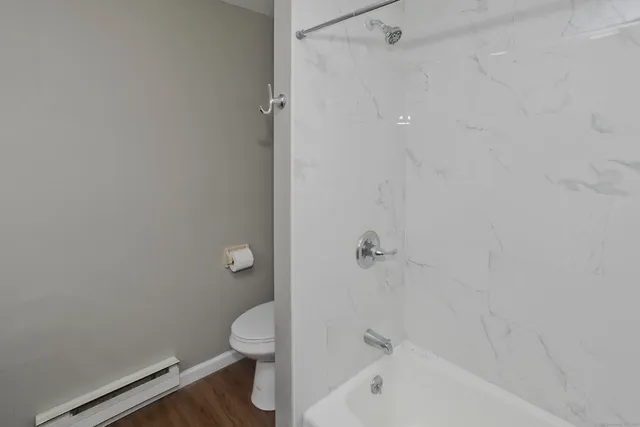 a bathroom with a granite countertop toilet and a bathtub