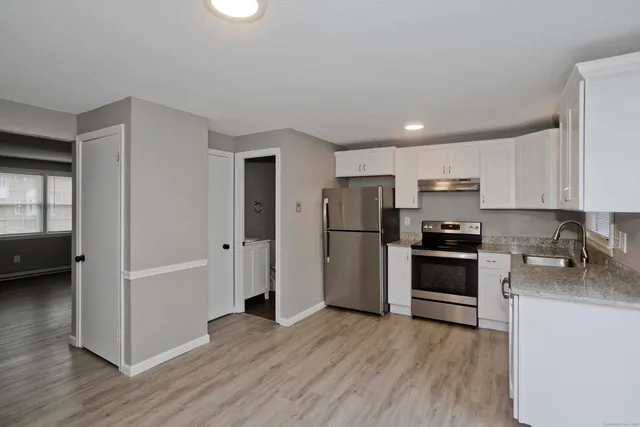 a kitchen with stainless steel appliances a refrigerator and a stove top oven