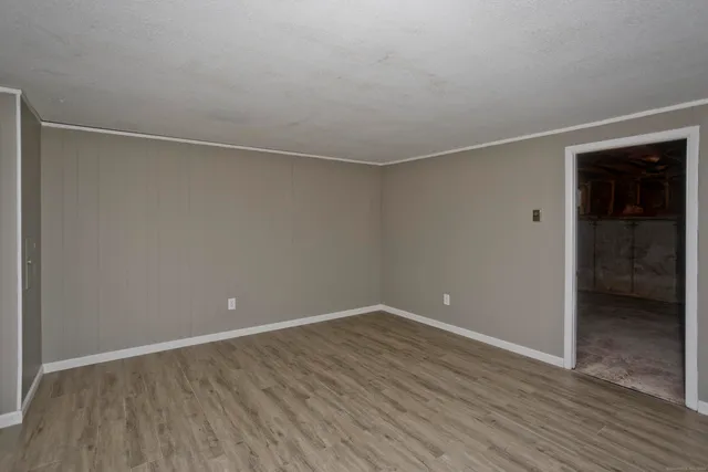 a view of an empty room with wooden floor