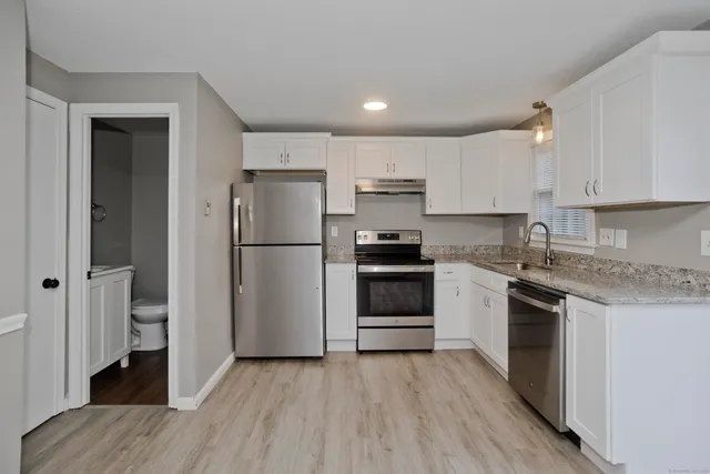 a kitchen with a refrigerator stove and white cabinets