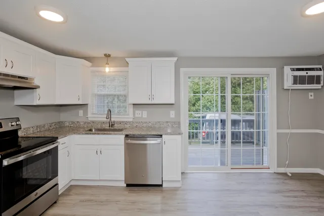 a kitchen with stainless steel appliances granite countertop a stove a sink and a microwave