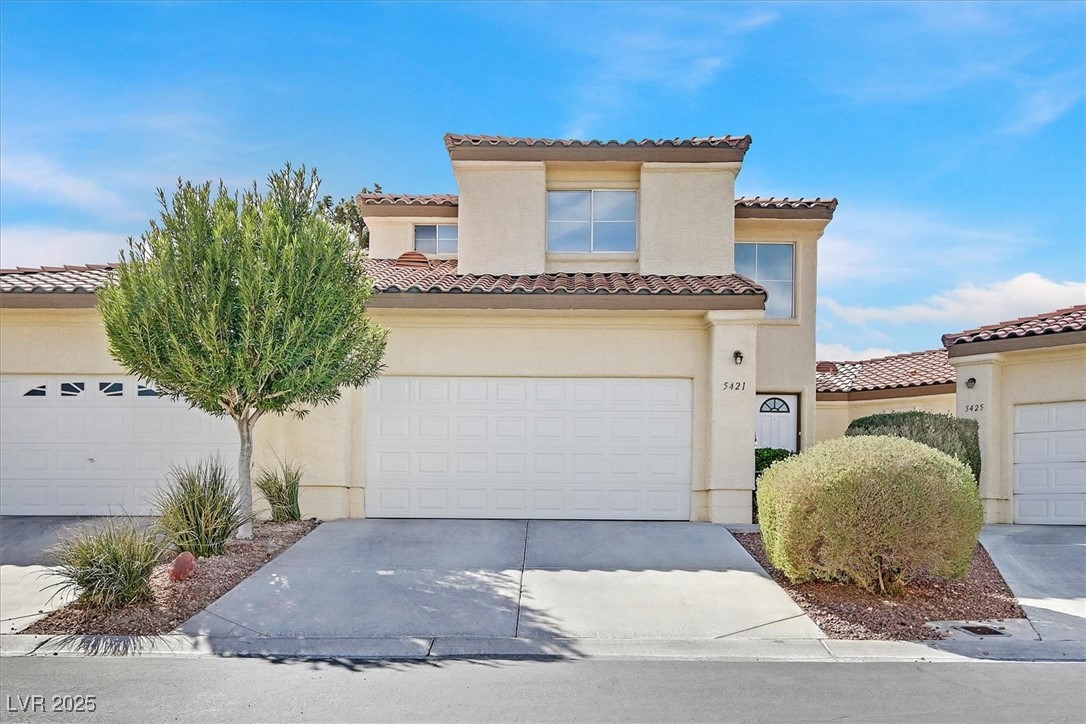 5421 Painted Mirage Road Las Vegas, NV 89149 - Photo 1 of 35 Mediterranean / spanish home featuring driveway, a tile roof, and stucco siding