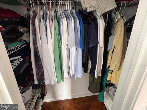 a view of walk in closet with clothes and shoes