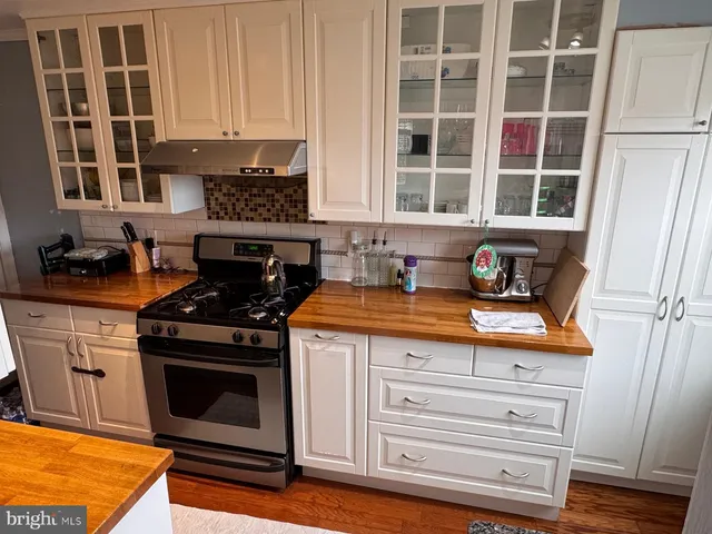 a kitchen with granite countertop wooden cabinets stainless steel appliances and a sink