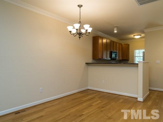 4528 Mistiflower Drive Raleigh, NC 27606 - Photo 7 of 25 a view of a room with wooden floor and chandelier