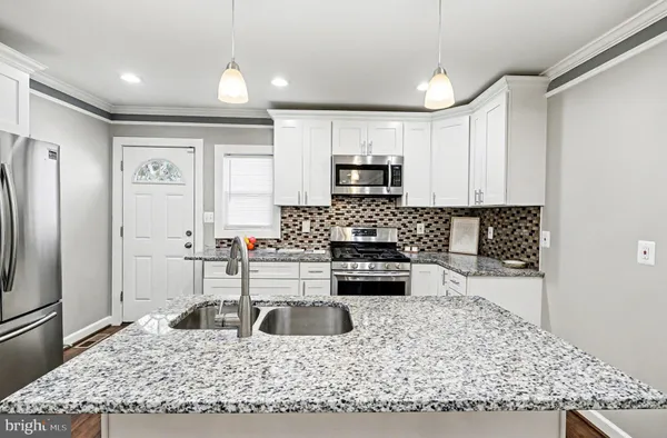 a kitchen with a stove a sink and a refrigerator