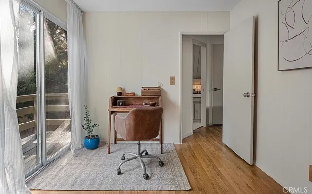 a view of a workspace with furniture and wooden floor