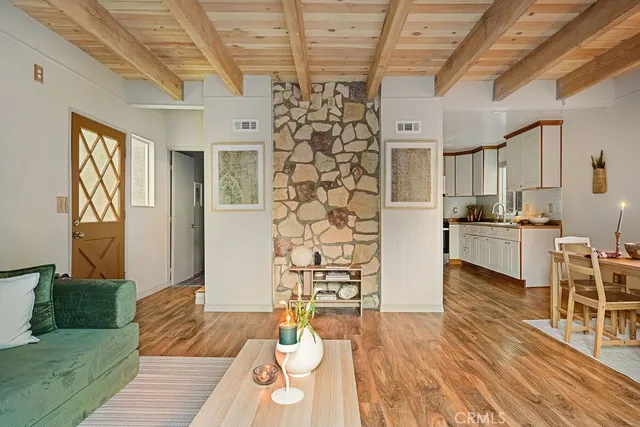 a living room with stainless steel appliances kitchen island granite countertop furniture and a wooden floor
