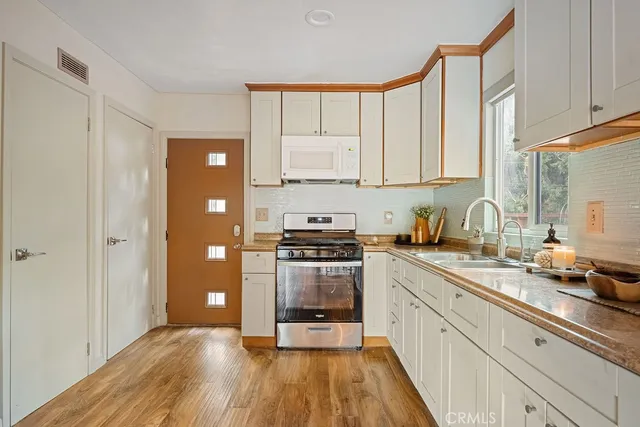 a kitchen with a sink a stove and cabinets