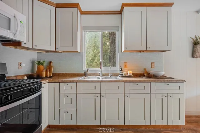 a kitchen with granite countertop white cabinets and stainless steel appliances