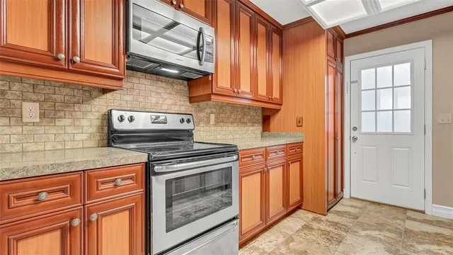 a kitchen with stainless steel appliances granite countertop cabinets and a stove top oven