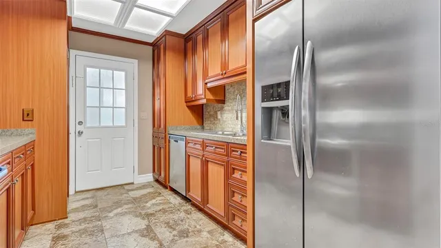 a kitchen with stainless steel appliances granite countertop a refrigerator and a stove top oven