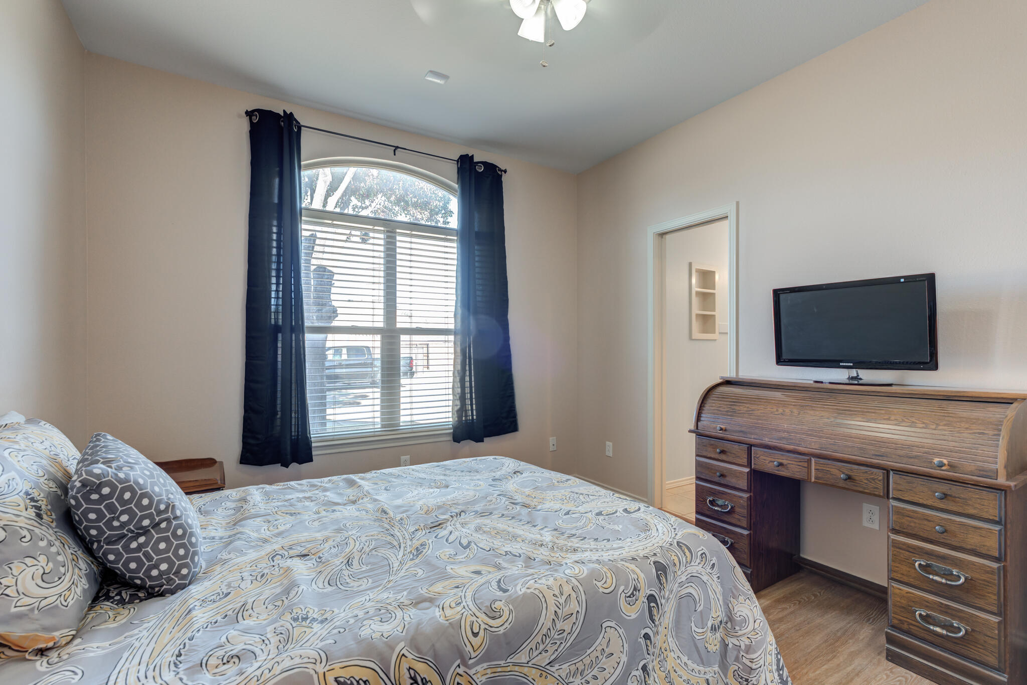 4707 106th Street Lubbock, TX 79424 - Photo 35 of 51 a bedroom with a large bed and a flat tv screen on dresser