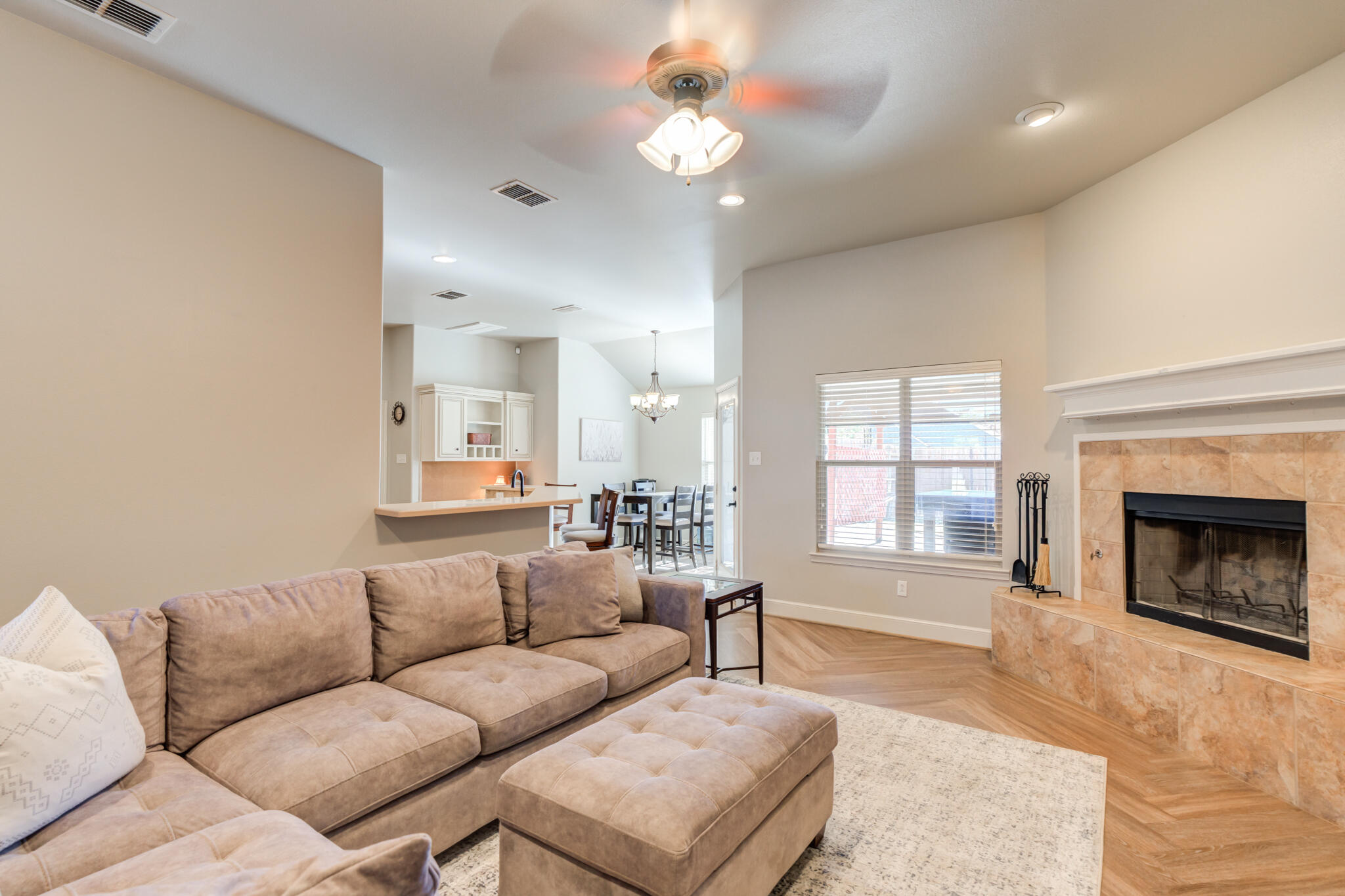 4707 106th Street Lubbock, TX 79424 - Photo 7 of 51 a living room with furniture a fireplace and a chandelier