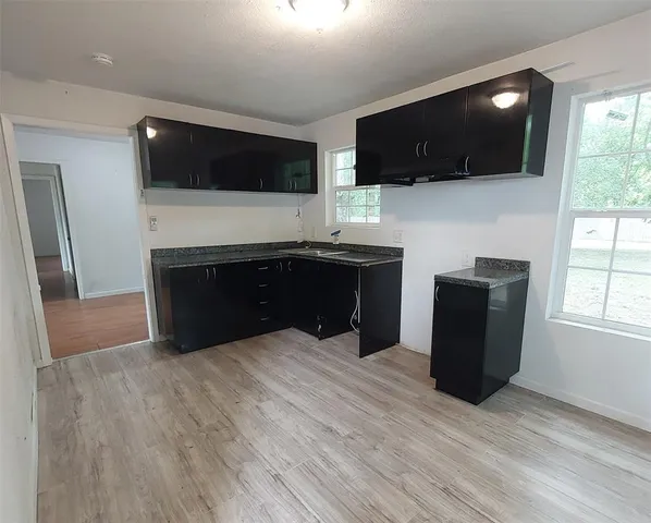 a view of kitchen with microwave cabinets and window