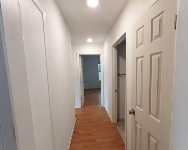 a view of a hallway with wooden floor and staircase