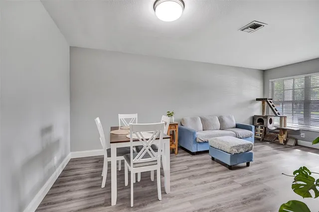 a view of a dining room with furniture wooden floor and a potted plant