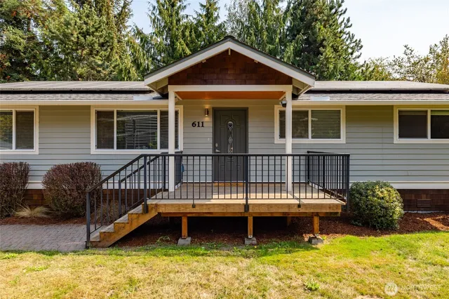 a view of a house with a roof deck and a small yard