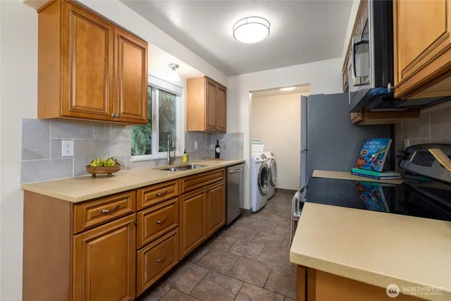 a kitchen with cabinets a sink and appliances