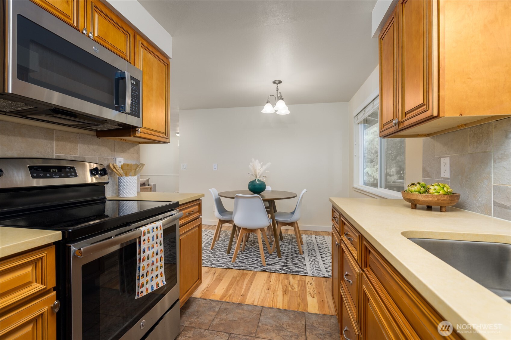 611 Whatcom Street La Conner, WA 98257 - Photo 10 of 26 a kitchen with stainless steel appliances a stove a sink a microwave cabinets and a dining table