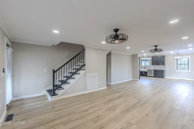 a view of empty room with wooden floor and window