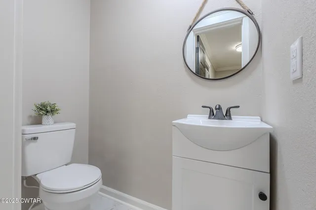 a bathroom with a toilet a sink and mirror