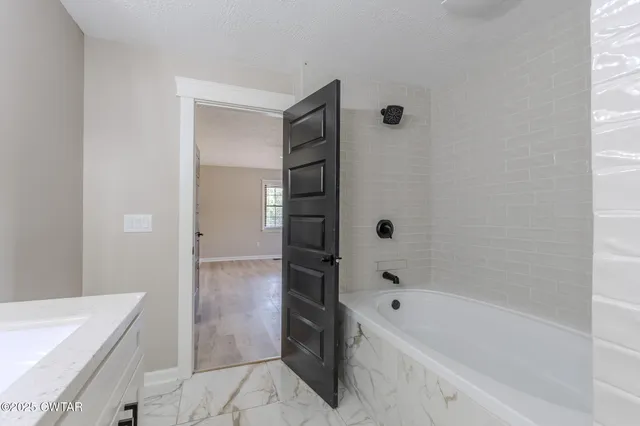 a bathroom with a bathtub and a sink