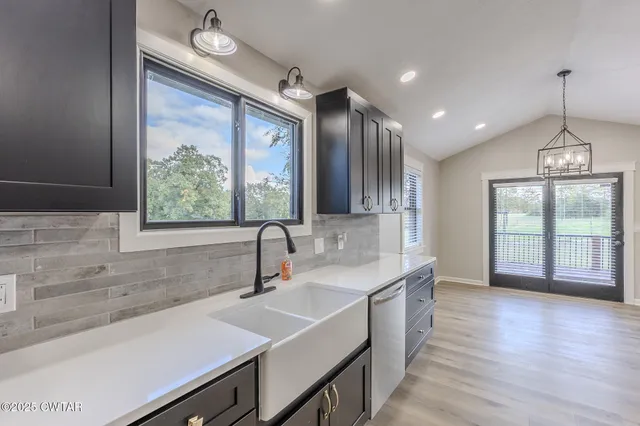 a kitchen with a sink a large window and wooden floor