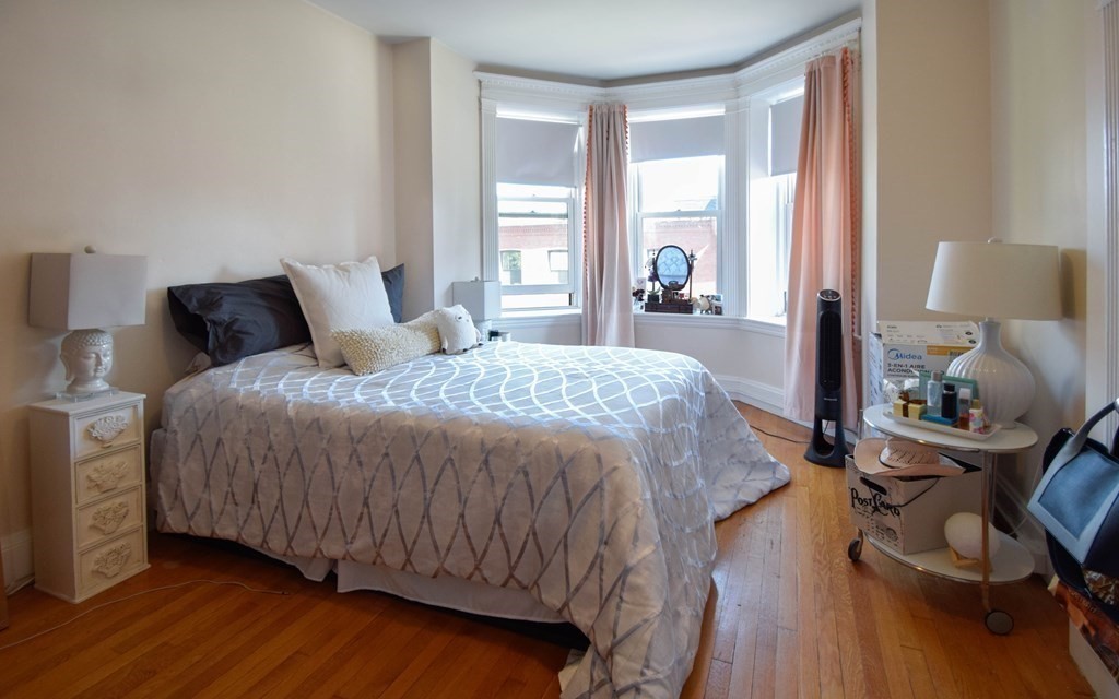 8 Garrison Street, Unit 409 Boston, MA 02116 - Photo 4 of 9 a bedroom with a bed a lamp and a large window