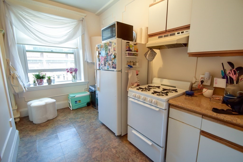 8 Garrison Street, Unit 409 Boston, MA 02116 - Photo 7 of 9 a kitchen with stainless steel appliances granite countertop a refrigerator and a stove top oven