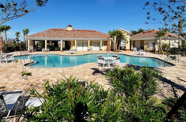 a view of a house with backyard water fountain and sitting area