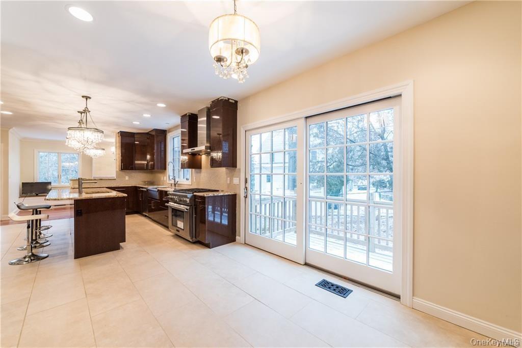 1 Elizabeth Road New Rochelle, NY 10804 - Photo 5 of 23 Kitchen with a chandelier, stainless steel stove, wall chimney exhaust hood, dark brown cabinets, and recessed lighting